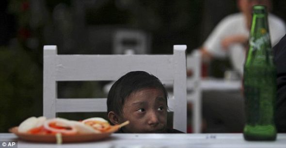 这位65厘米的18岁男子刚能看到桌面。 这位65厘米的18岁男子刚能看到桌面。