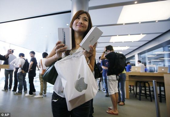 香港的一家苹果专卖店,一名女消费者向摄影师展示她新买的iPhone 5 香港的一家苹果专卖店,一名女消费者向摄影师展示她新买的iPhone 5