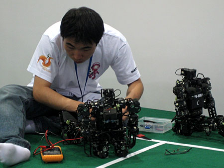 图文:参与类人机器人足球赛的同学进行调试_科