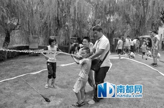 亲子合力使用消防水带体验灭火。 亲子合力使用消防水带体验灭火。