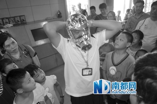 老师教导青少年学习穿戴防毒面具的正确方法。 老师教导青少年学习穿戴防毒面具的正确方法。