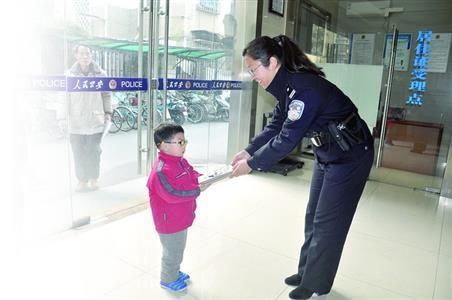 小朋友到派出所将钱包交给民警。警方供图 小朋友到派出所将钱包交给民警。警方供图