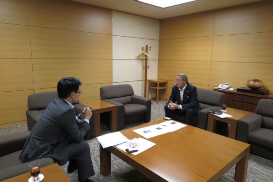 图为蔡成平正在采访龟甲万社长堀切功章