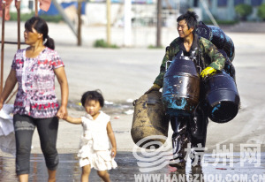渔民李传军身背四个桶,手上还提了个桶,前往捞油地点。 渔民李传军身背四个桶,手上还提了个桶,前往捞油地点。