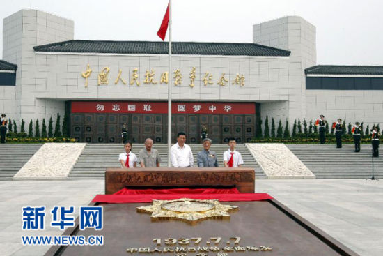 2014年7月7日,首都各界在中国人民抗日战争纪念馆隆重集会,纪念全民族抗战爆发77周年。这是习近平和抗战老战士以及 少年儿童一起按下启动按钮,为“独立自由勋章”雕塑揭幕。 2014年7月7日,首都各界在中国人民抗日战争纪念馆隆重集会,纪念全民族抗战爆发77周年。这是习近平和抗战老战士以及 少年儿童一起按下启动按钮,为“独立自由勋章”雕塑揭幕。