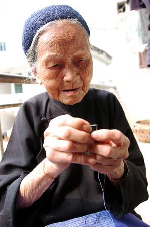 图文:老人穿针引线缝补衣裳