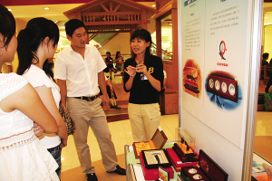 旅游局机关干部车晓昱(右)在麦凯乐青岛总店向