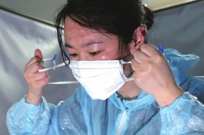 队员摘下口罩和护目镜,脸上布满了汗水 和皮筋勒出的红印.