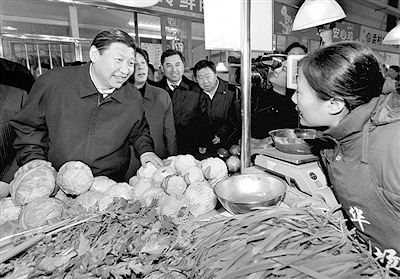 2009年,习近平在天津一菜市场同商户交谈。新华社发