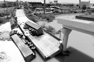 6月19日,出事的匝道桥和4辆满载瓷土的重载五型货车掉落地上。 新华社发