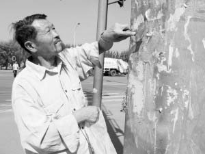 老汉15年坚持铲小广告数万张