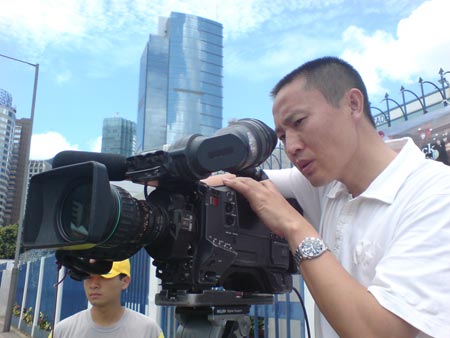 图文:摄像贺学国在烈日下工作