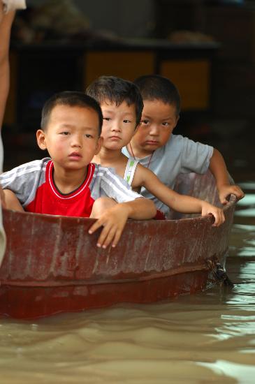 图文:安徽省霍邱县临淮新镇3名儿童乘木盆出行