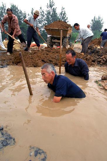 图文:安徽省凤台先庄村村民在水中堵管涌
