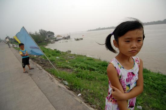 图文:一名女孩在安徽淮南淮河干堤上观看水情
