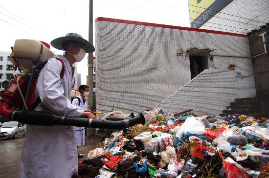 图文:卫生局工作人员为垃圾堆放处进行消毒