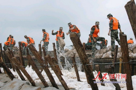 图文:官兵用沙袋木桩筑长城。