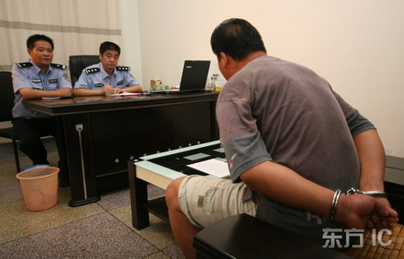 圖文：民警在對販賣假幣的犯罪嫌疑人進行審訊