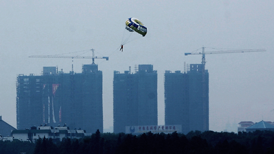 图文:汽艇降落伞爱好者飘在城市上空