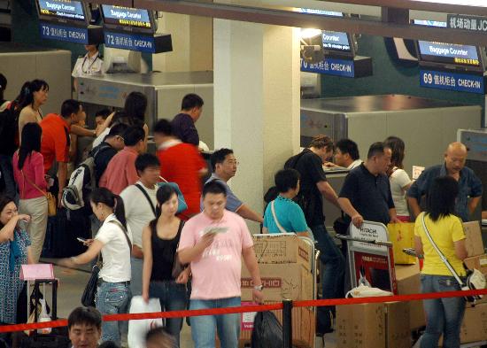 图文:返程旅客在上海虹桥机场办理登机手续