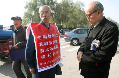 图文:刘先生身披广告衫推销自己的专利