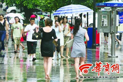 12点30分,两行人赤脚走在雨水浸湿的解放碑步行街上享受清凉