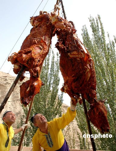 图:新疆吐鲁番世界大馕坑出炉烤双牛