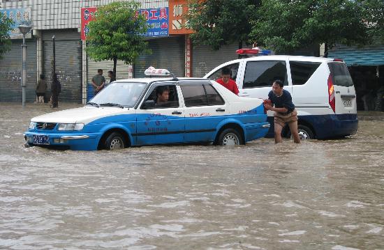 图文:贵州桐梓出租车在众人帮助下涉水前行