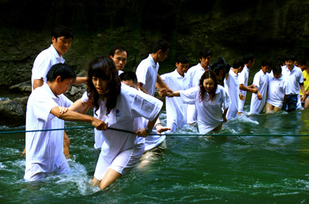 图文:志愿者组成人墙搀扶女士过河