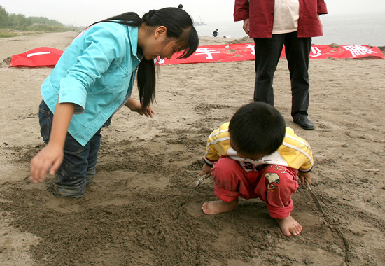 图文:女孩双脚埋进沙子里
