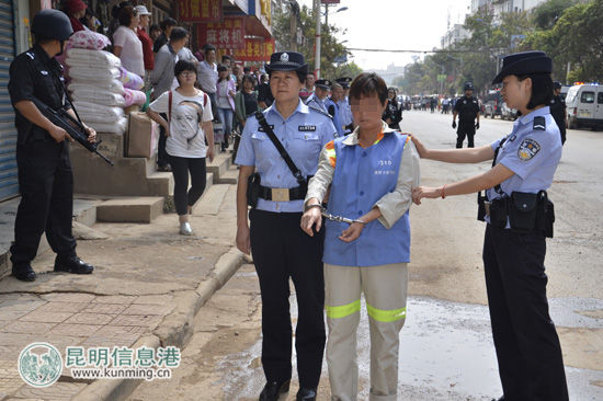 涉案的嫌疑人(女)在警方的押解下对作案现场进行指认