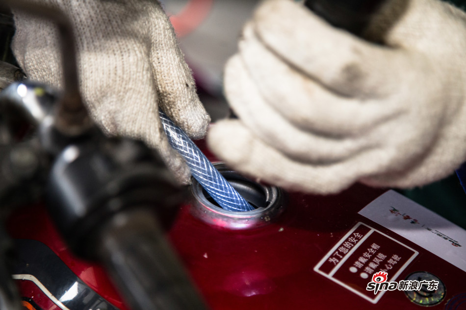 工作人员仔细检查油箱是否有余油