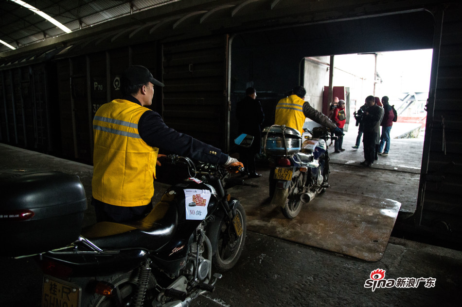 火车站工作人员把摩托车依次推进车厢