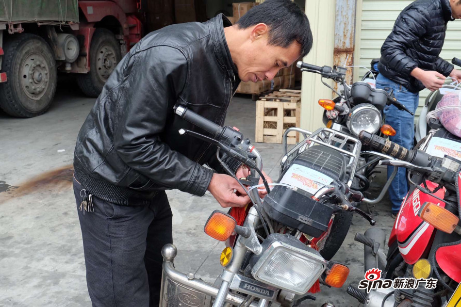 摩托车工友在托运前依依不舍检查自己的坐骑