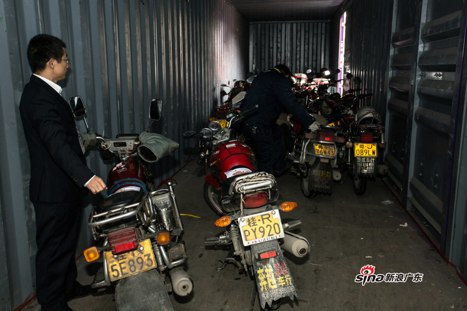 工作人员指挥把摩托车在货柜里整齐排好