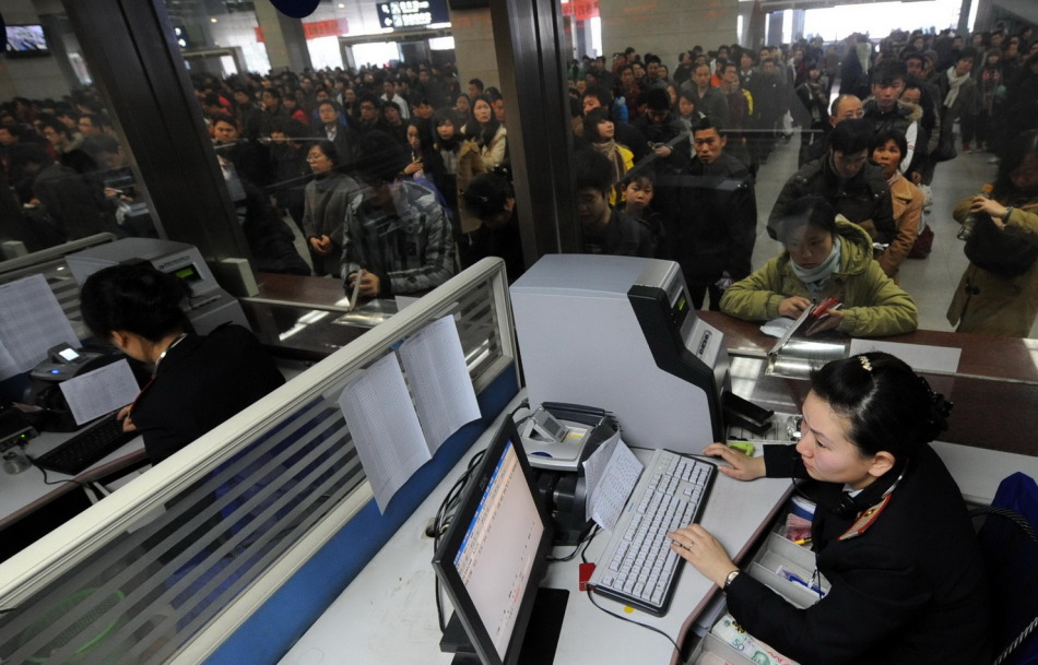 南京火车站售票处售票员在为旅客售票