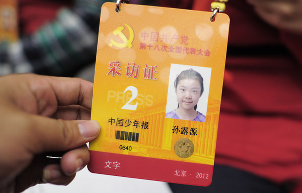 十八大花絮:小记者吸引老外目光; 图为:小记者的采访证; 11岁小记者跑