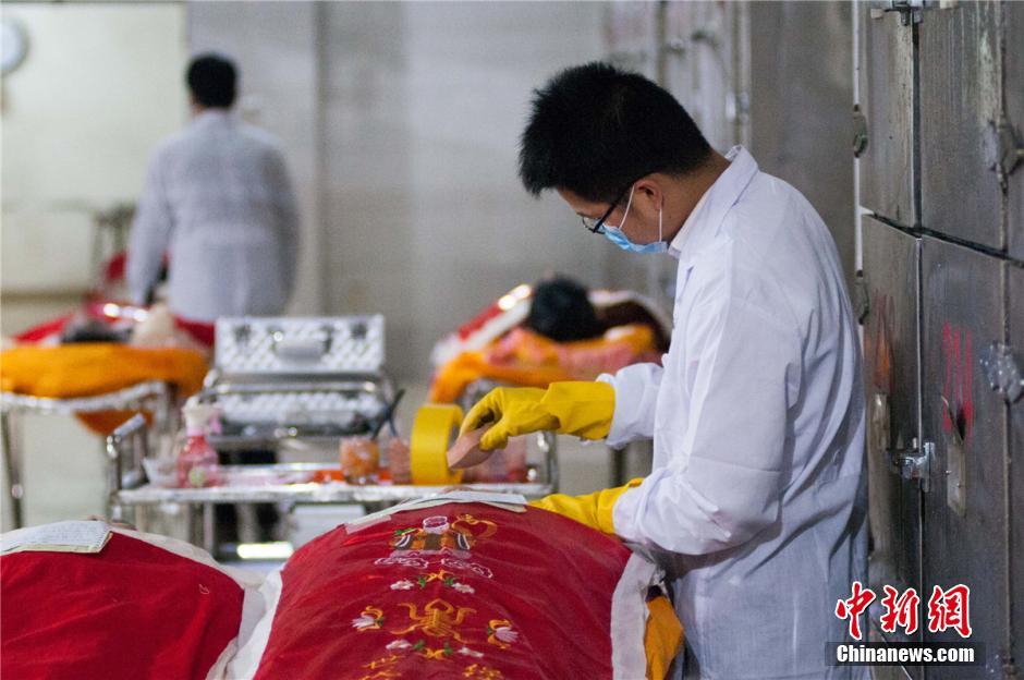 图为3月31日,广西柳州市殡葬管理中心遗体化妆师正在为遗体化妆.