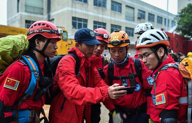 图为深圳山地救援队的成员在事故现场商议救援方案。