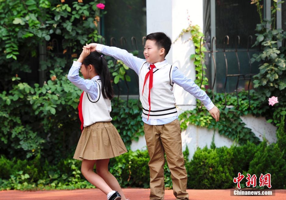 当日,济南胜利大街小学上演校服展示秀,小学生们身着自主设计的8款