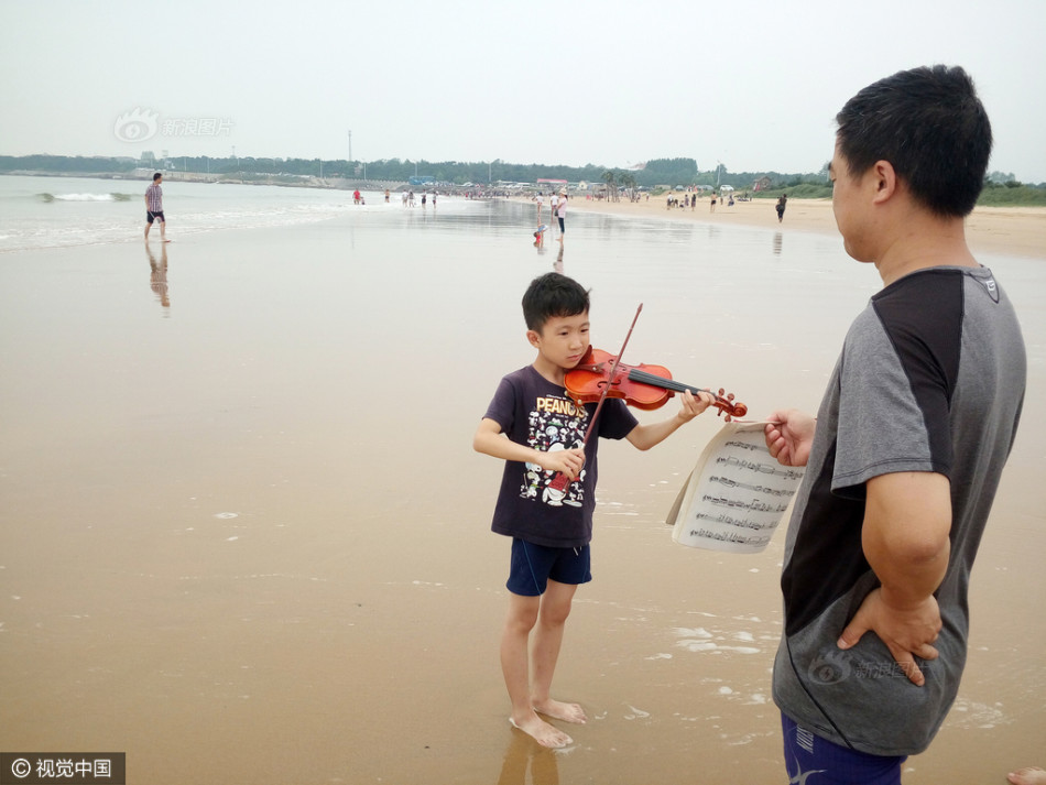 男孩海边练提琴父母称边玩边练效果好,男孩海