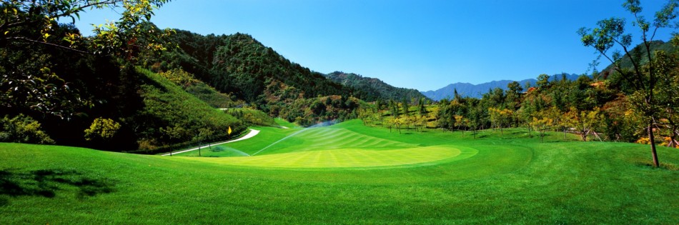 第18洞发球台视角，球手凝神准备开球，球道如画卷般向远方山麓展开