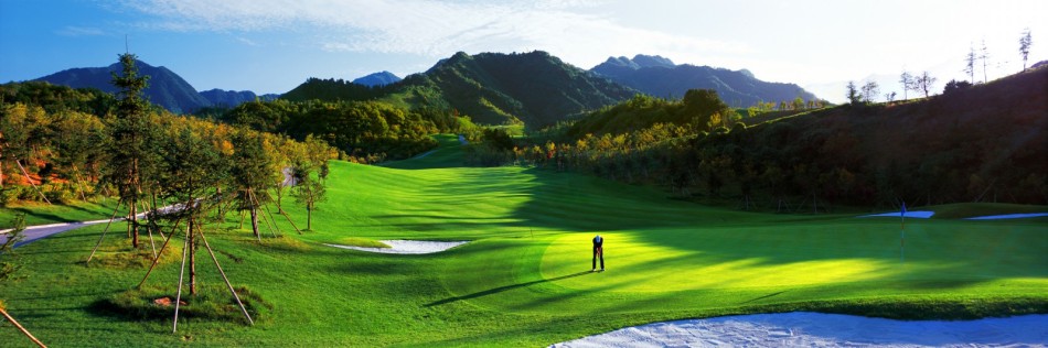 从山顶俯瞰，整个球场脉络尽收眼底，球道与果岭如镶嵌在群山间的绿宝石