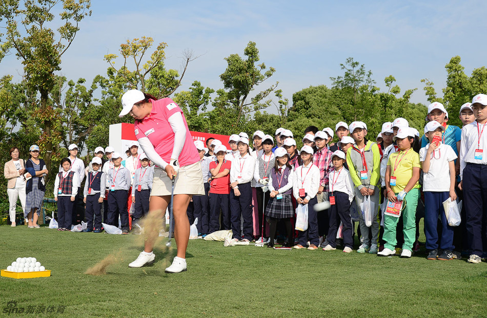 冯珊珊手把手调整一位小球手的挥杆姿势,动作轻柔而专业,小球手在全神贯注地感受和领悟。