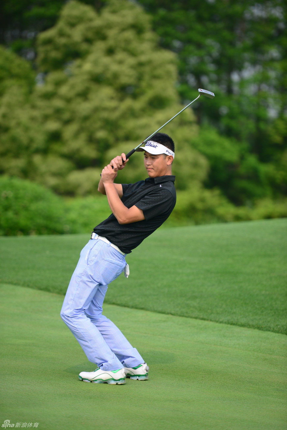 选手在沙坑中屈膝准备击球,沙粒微溅,专注神情展现高超的短杆技巧