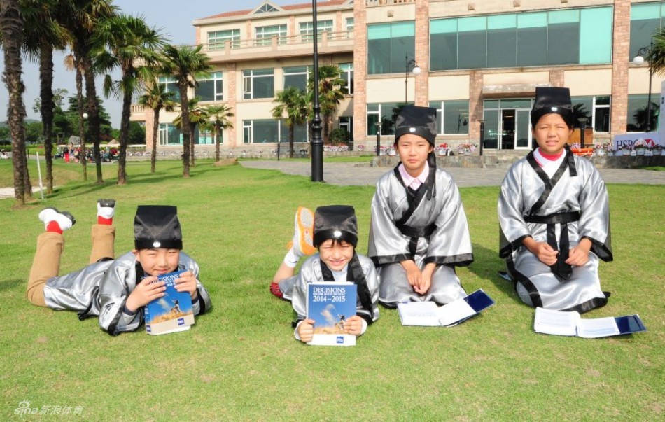 绿草如茵的赛场上，小球员们三三两两结伴行走，或自信挥杆，或交流切磋，阳光洒在年轻的身影上，充满了青春的朝气与运动的活力。