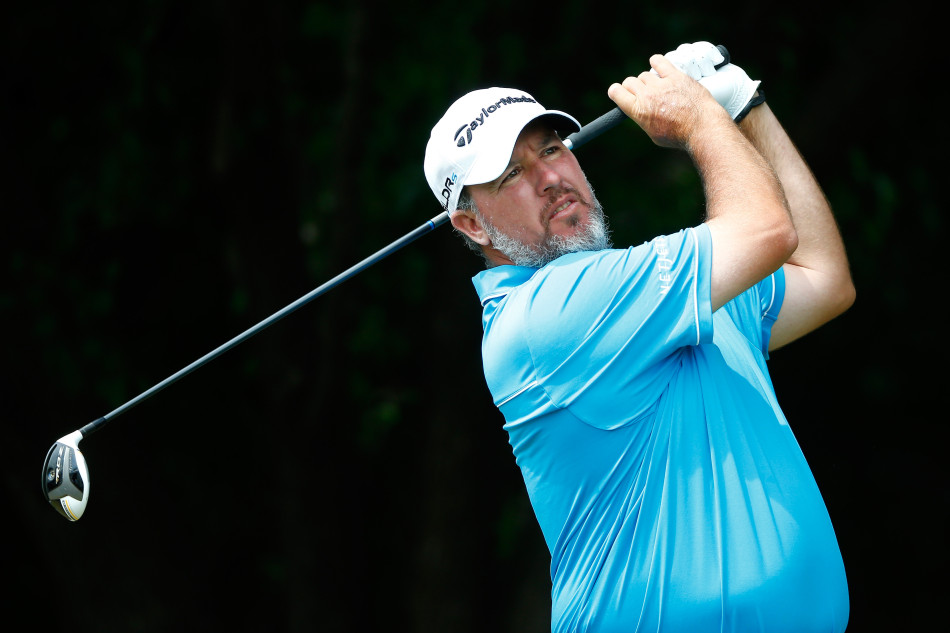 职业球手在发球台专注研究进攻线路，权衡风险与回报，以做出最佳开球策略选择。