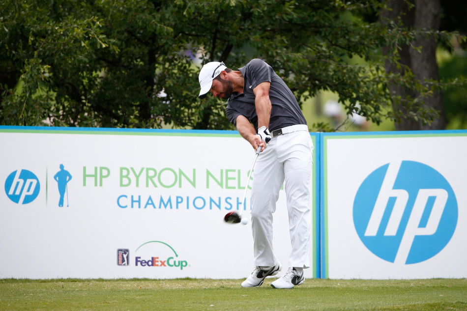 球员面对果岭边的短切球，全神贯注于杆头与球的接触点，这是决定救球成败的关键一击。