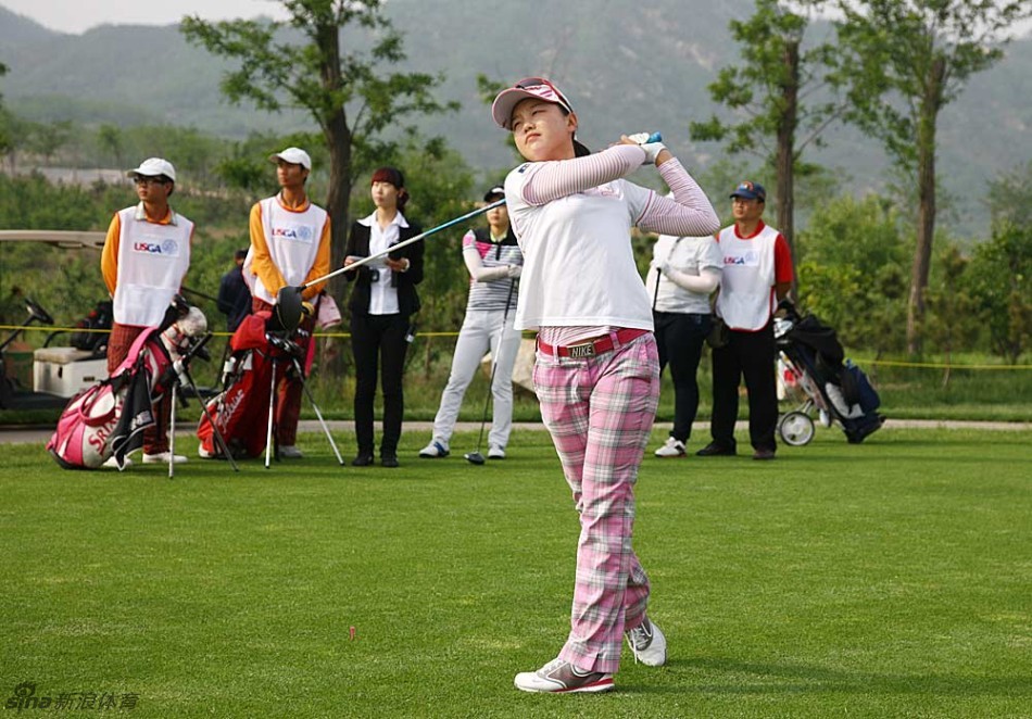 泰国选手娜丽萨拉在果岭边仔细观察线路，轻柔的微风拂过她的帽檐，优雅与专注并存。