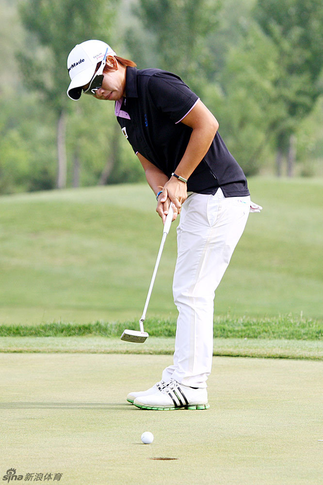 中国球员张玉阳在球道上大步向前，步伐坚定有力，身后是南山球场开阔的风景与未竟的征途。